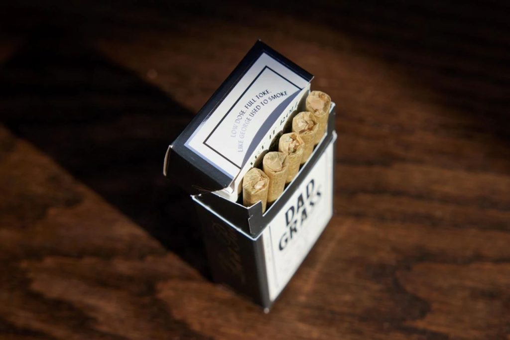 Close-up of a box of hemp CBD pre-rolls on a wooden background.