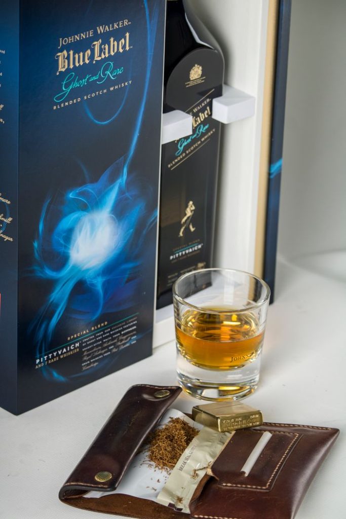 Elegant display of whiskey, glass, and leather case, perfect for a classy setting.