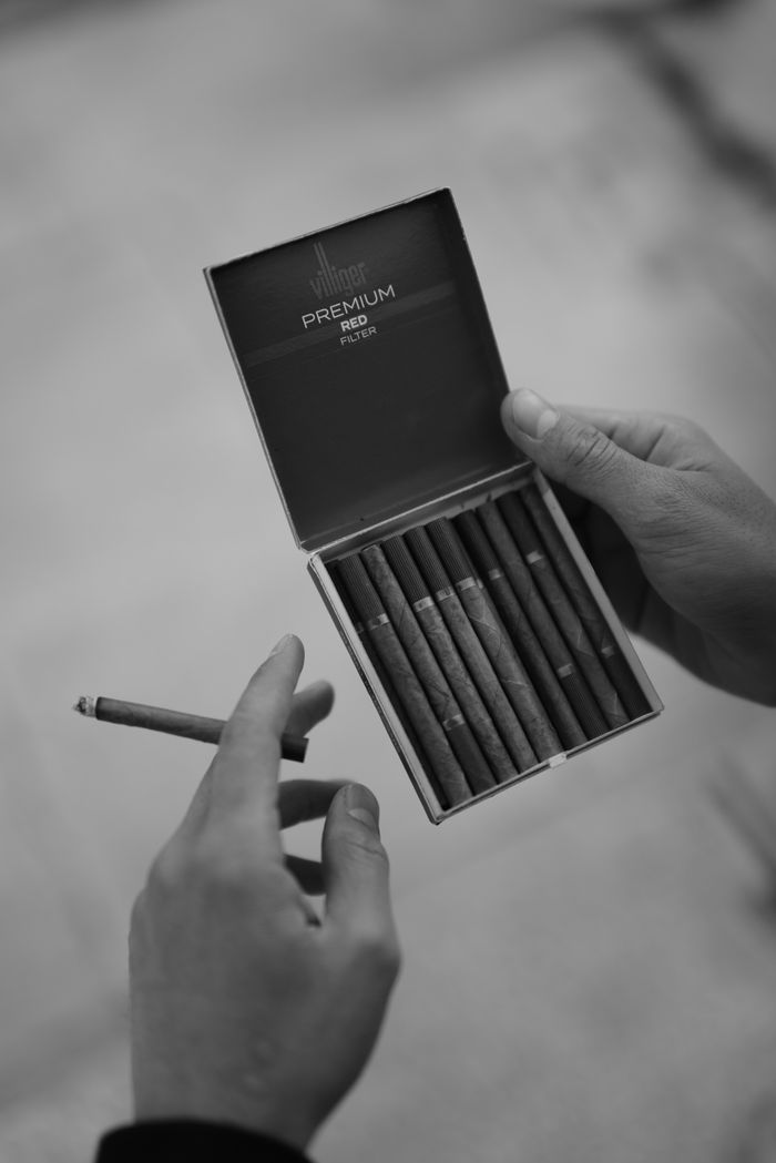 Crafting Captivating Headlines: Your awesome post title goes here Hands holding a box of premium cigarettes with one cigarette taken out.