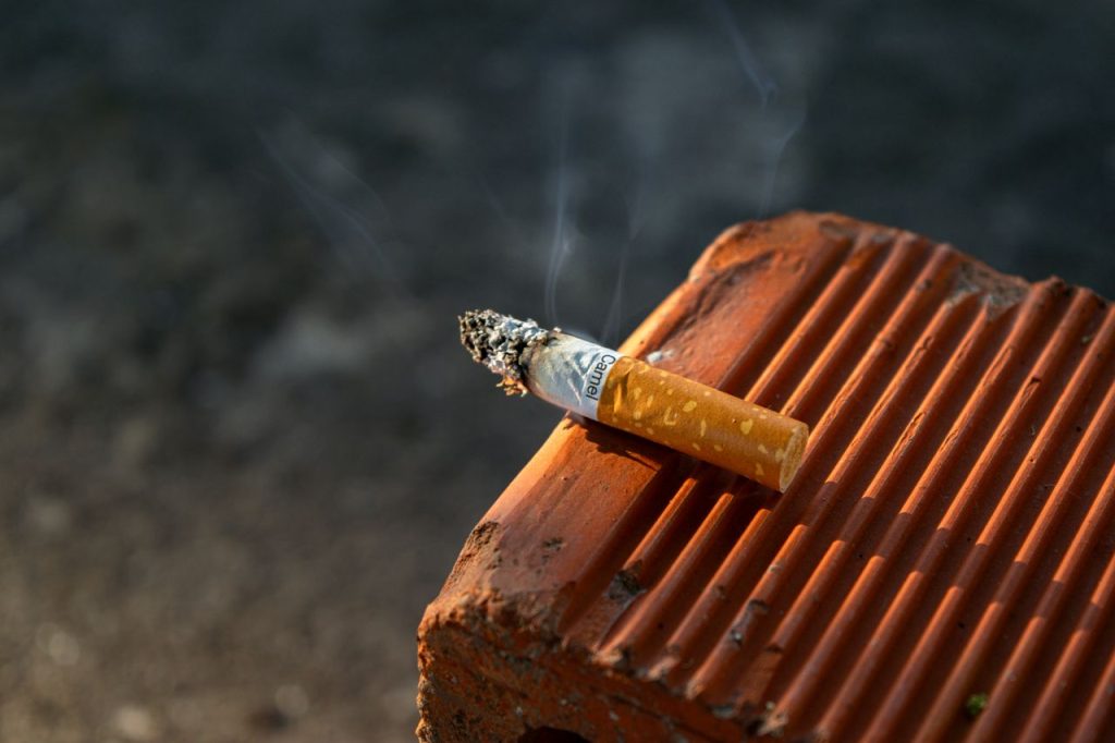 The Art of Drawing Readers In: Your attractive post title goes here Close-up of a smoked cigarette butt resting on a textured clay surface in outdoor light.