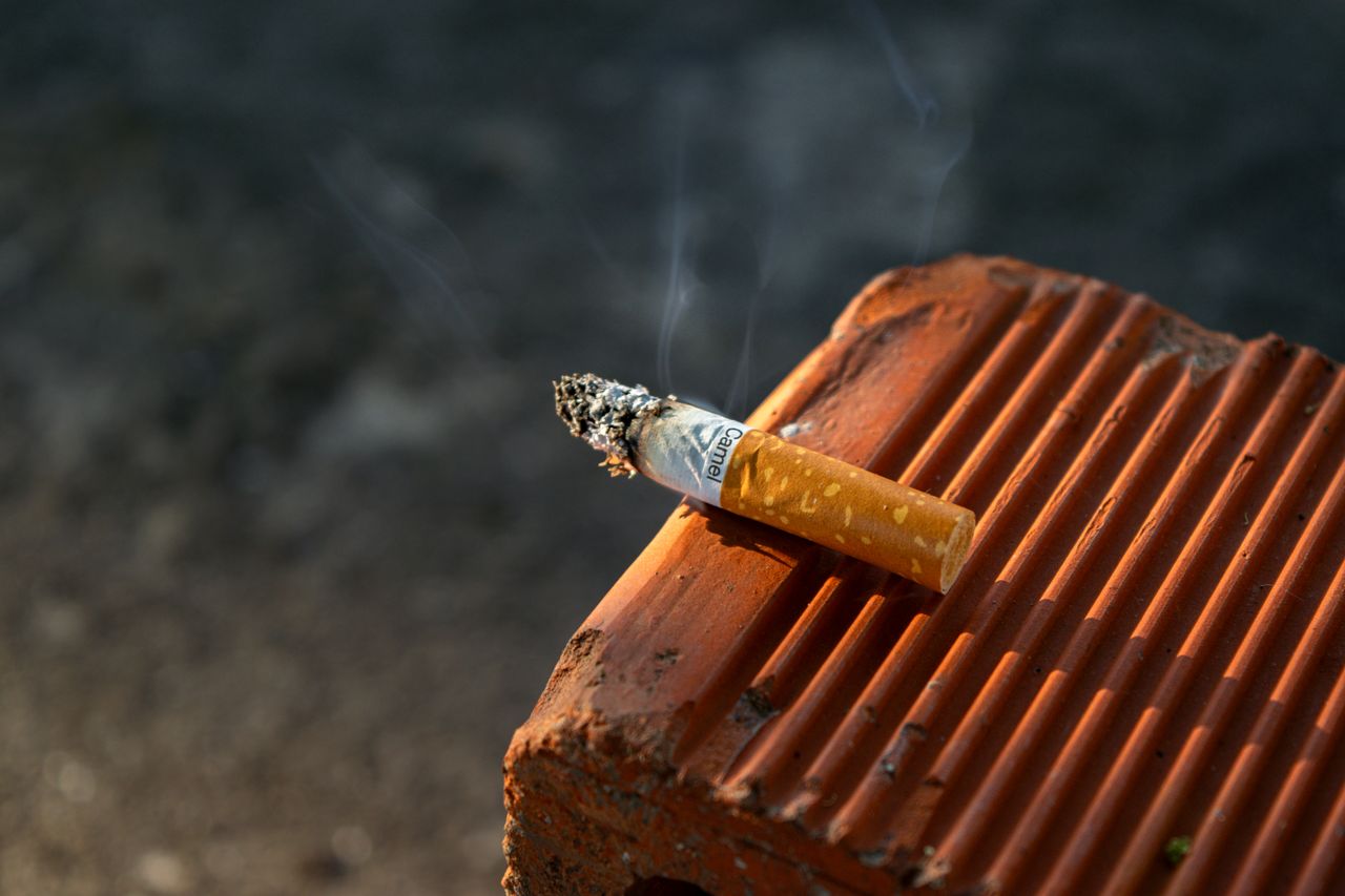 The Art of Drawing Readers In: Your attractive post title goes here Close-up of a smoked cigarette butt resting on a textured clay surface in outdoor light.