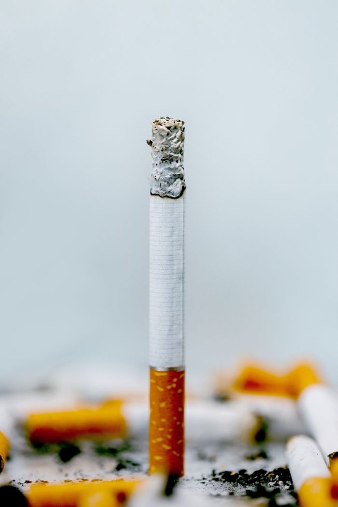 Detailed image depicting a burning cigarette, emphasizing tobacco and nicotine addiction.